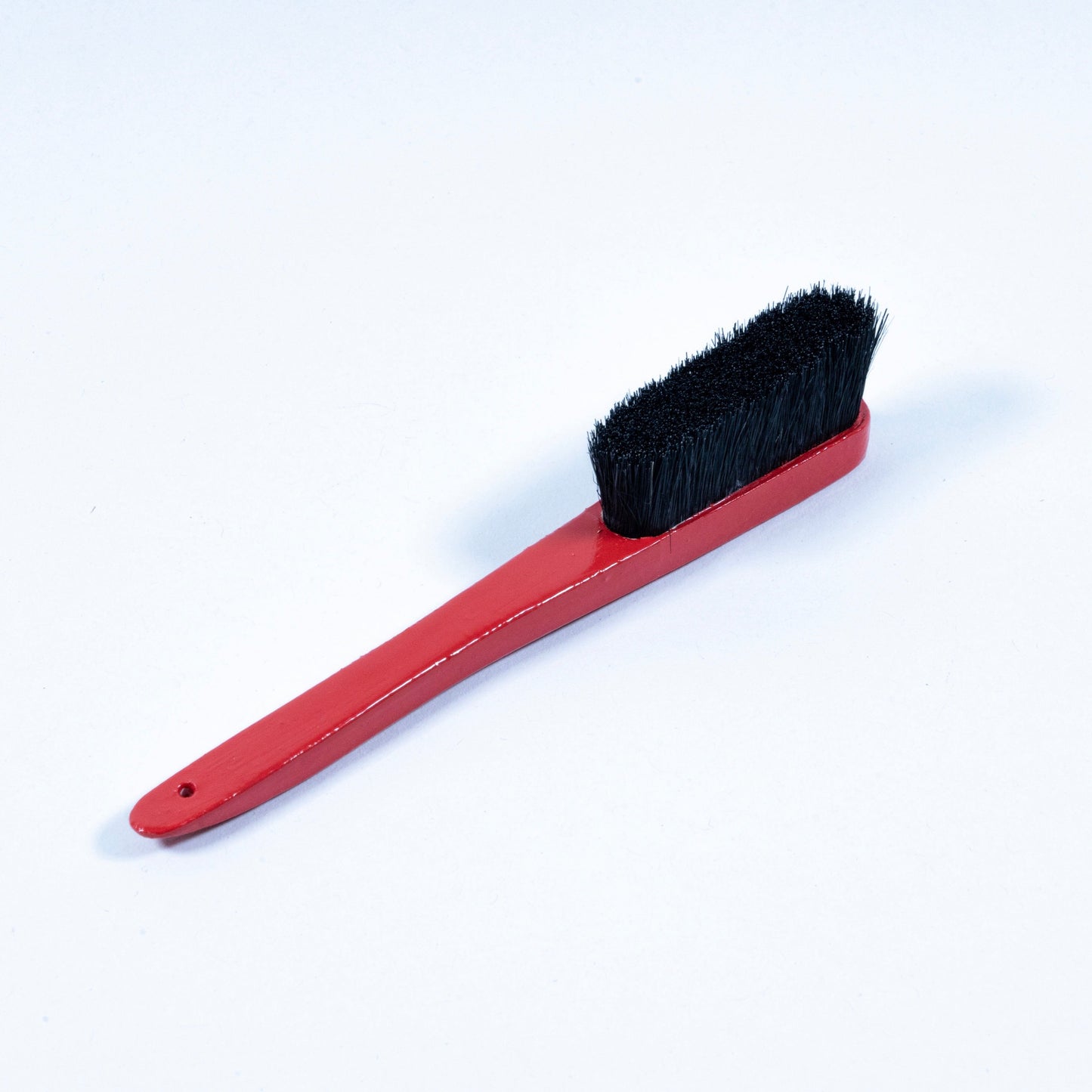 Primer cepillo Grillo en madera de haya y cerdas de jabalí, respetuoso con la roca y el medio ambiente. Pintado a mano en color rojo, logo grabado a láser en la parte superior trasera y disponible con las cerdas en color negro o natural.