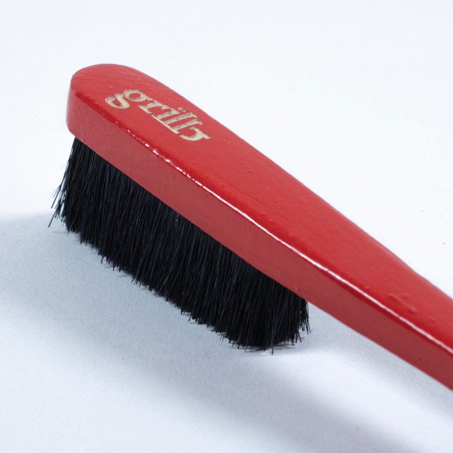 Primer cepillo Grillo en madera de haya y cerdas de jabalí, respetuoso con la roca y el medio ambiente. Pintado a mano en color rojo, logo grabado a láser en la parte superior trasera y disponible con las cerdas en color negro o natural.