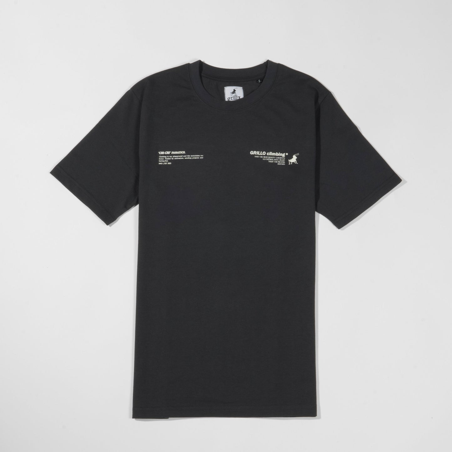 Parte delantera de la camiseta gris oscuro, manga corta, cuello acanalado y 100% algodón. Diseño serigrafiado arriba a la derecha e izquierda de la camiseta, al nivel del pecho.