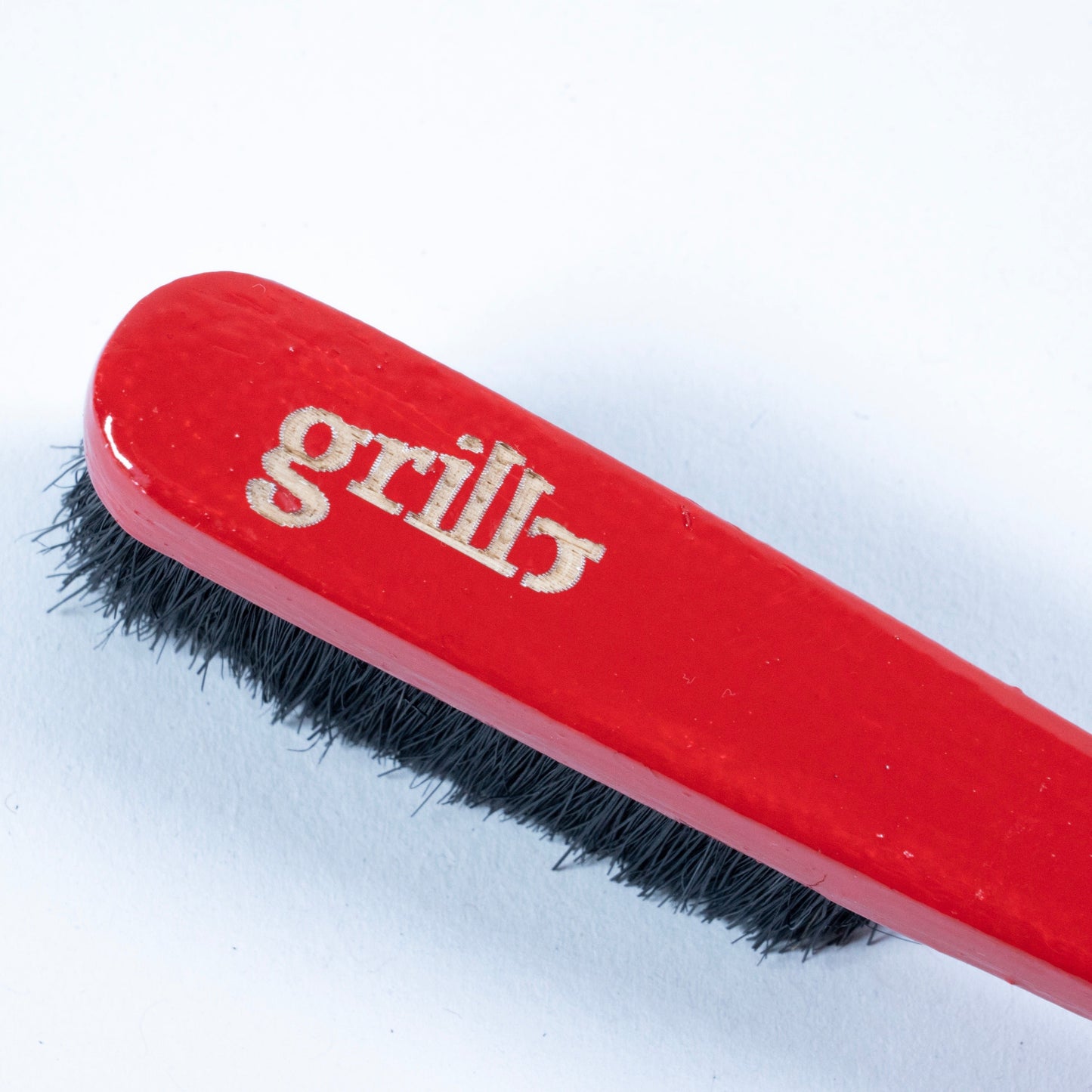Primer cepillo Grillo en madera de haya y cerdas de jabalí, respetuoso con la roca y el medio ambiente. Pintado a mano en color rojo, logo grabado a láser en la parte superior trasera y disponible con las cerdas en color negro o natural.