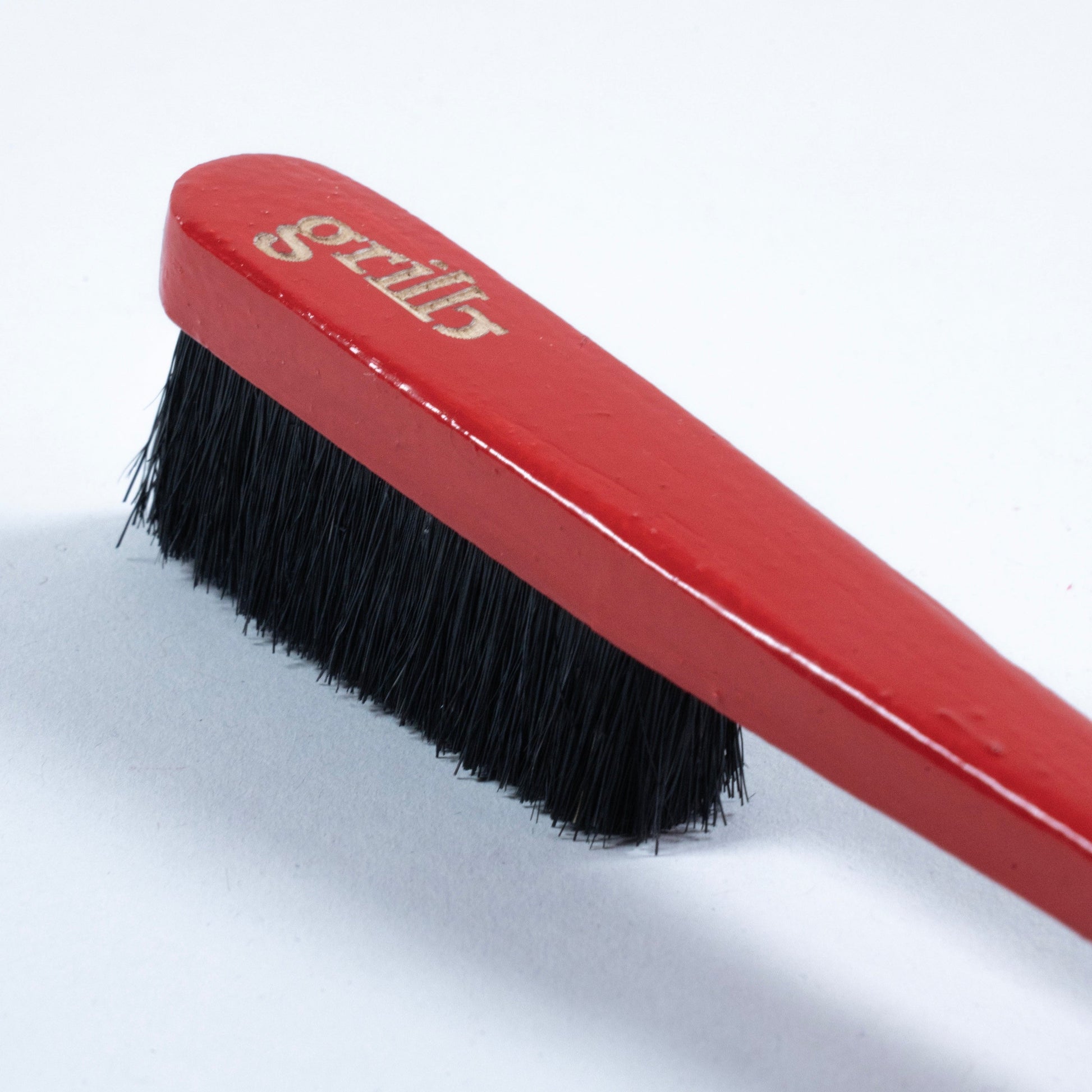 Primer cepillo Grillo en madera de haya y cerdas de jabalí, respetuoso con la roca y el medio ambiente. Pintado a mano en color rojo, logo grabado a láser en la parte superior trasera y disponible con las cerdas en color negro o natural.
